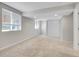 A finished basement area with neutral carpet, bright windows with blinds, and closet space at 1288 S Beeler Ct, Denver, CO 80247