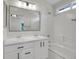 Bathroom with double sink vanity, framed mirror, tub and shower combo and lots of light from a small window at 1288 S Beeler Ct, Denver, CO 80247