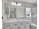 Updated bathroom with vanity, sink, large mirror, modern lighting, and tiled shower at 1288 S Beeler Ct, Denver, CO 80247