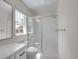 Bright bathroom with white cabinets, a glass shower, and a large window with natural light at 1288 S Beeler Ct, Denver, CO 80247