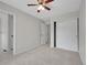A carpeted bedroom features a ceiling fan, neutral walls, and access to the ensuite bathroom and closets at 1288 S Beeler Ct, Denver, CO 80247
