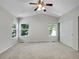 A bright carpeted bedroom with three windows and a closet with sliding doors at 1288 S Beeler Ct, Denver, CO 80247