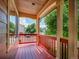 Charming covered front porch featuring warm wood floors and red railings, offering a relaxing outdoor space at 1288 S Beeler Ct, Denver, CO 80247