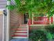 Welcoming front porch with red railings, leading to the entrance of this charming home at 1288 S Beeler Ct, Denver, CO 80247
