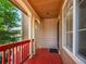 Quaint covered front porch with red railings, providing a cozy spot to enjoy the neighborhood views at 1288 S Beeler Ct, Denver, CO 80247