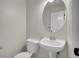A half bathroom features a pedestal sink, a toilet, and an oval mirror at 1288 S Beeler Ct, Denver, CO 80247