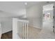 Upper hallway with carpet, white railings, and a view to a bright bedroom beyond the doorway at 1288 S Beeler Ct, Denver, CO 80247