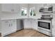 Modern kitchen featuring stainless steel appliances, white cabinetry, and a corner sink with natural light at 1288 S Beeler Ct, Denver, CO 80247