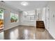 Bright and airy living room with wood floors, steps up to the kitchen, and a sliding glass door to the patio at 1288 S Beeler Ct, Denver, CO 80247