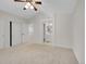 A spacious main bedroom features a ceiling fan, neutral carpet, and a doorway to the ensuite bathroom at 1288 S Beeler Ct, Denver, CO 80247