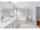Contemporary bathroom with dual sinks, quartz countertops, a soaking tub, and a glass-enclosed shower at 19410 E Ithaca Pl, Aurora, CO 80013