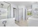 Bright bathroom featuring a shower, soaking tub, and modern fixtures at 19410 E Ithaca Pl, Aurora, CO 80013