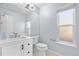 Bright bathroom featuring a modern vanity with white cabinets, a toilet, and a window at 19410 E Ithaca Pl, Aurora, CO 80013