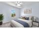Serene bedroom featuring a cozy bed with blue accents, a window view, and calming artwork at 19410 E Ithaca Pl, Aurora, CO 80013