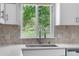 Kitchen sink featuring a modern faucet, quartz countertops, and a view of the backyard at 19410 E Ithaca Pl, Aurora, CO 80013