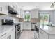 Stylish kitchen with stainless appliances, white cabinets, and access to backyard at 19410 E Ithaca Pl, Aurora, CO 80013