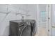 Modern laundry room with front load washer and dryer and wire shelving above at 19410 E Ithaca Pl, Aurora, CO 80013