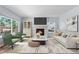 Bright and spacious living room with a cozy fireplace, large windows, and elegant furnishings at 19410 E Ithaca Pl, Aurora, CO 80013