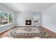 Cozy living room with a fireplace, large windows offering natural light, and hardwood floors at 19410 E Ithaca Pl, Aurora, CO 80013