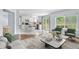 Open-concept living room flows into the kitchen with breakfast bar seating, neutral colors, and access to an outdoor deck at 19410 E Ithaca Pl, Aurora, CO 80013