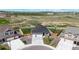 Aerial view of a gray house with a two-car garage, landscaped yard, and fenced backyard with a play set at 13488 Wabash St, Thornton, CO 80602