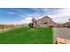 Backyard with well-maintained lawn, playground, and gravel area, surrounded by a wooden fence at 13488 Wabash St, Thornton, CO 80602