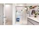 Bright bathroom featuring a glass shower with a bench and a single vanity with plants at 13488 Wabash St, Thornton, CO 80602