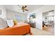 Bedroom with ceiling fan, and large window; living and dining areas visible through doorway at 13488 Wabash St, Thornton, CO 80602
