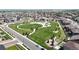 Aerial view of a neighborhood park with lush green space, walking paths, playground, and surrounding houses at 13488 Wabash St, Thornton, CO 80602
