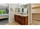 Bathroom with double sinks, dark wood vanity, and walk-in closet access at 6292 Kilmer Loop # 201, Golden, CO 80403