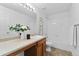 Bright bathroom features a single sink vanity, framed mirrors, and a tiled shower and tub combination at 10933 E 115Th Pl, Commerce City, CO 80640