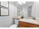 Charming half-bath featuring vanity with framed art, providing a convenient and stylish space for guests at 10933 E 115Th Pl, Commerce City, CO 80640