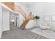 Bright foyer with wood staircase, neutral walls, gray carpet, and high ceilings at 10933 E 115Th Pl, Commerce City, CO 80640