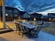 Backyard features outdoor table, gas fire pit, professional landscaping, and exterior lighting at 1925 Peregrine Dr, Brighton, CO 80601