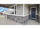 Inviting home entrance with a modern blue front door, stone veneer, and wood-look siding at 1925 Peregrine Dr, Brighton, CO 80601