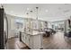 Bright, open-concept kitchen with a large island flowing into the dining and living area at 1925 Peregrine Dr, Brighton, CO 80601