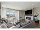 Comfortable living room with a cozy gray couch, fireplace, and a sliding glass door to the patio at 1925 Peregrine Dr, Brighton, CO 80601