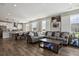 Living room offering natural light, an open-concept kitchen, and a comfortable gray couch with accent pillows at 1925 Peregrine Dr, Brighton, CO 80601