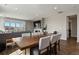 Open-concept living room with fireplace, large TV, and a dark-wood dining table with seating for six at 1925 Peregrine Dr, Brighton, CO 80601