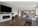 Open concept living room with a fireplace, large tv, and stainless steel appliances in the background at 1925 Peregrine Dr, Brighton, CO 80601