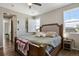 Cozy main bedroom with a decorative headboard, ceiling fan, and bright windows with shutter blinds at 1925 Peregrine Dr, Brighton, CO 80601