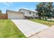 Spacious home with a long driveway, attached garage, and lush green lawn on a sunny day at 6994 W Hinsdale Dr, Littleton, CO 80128