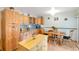 Well-appointed kitchen featuring natural wood cabinets, granite countertops, and a cozy dining area at 6994 W Hinsdale Dr, Littleton, CO 80128