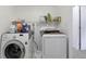 Functional laundry room with a modern washer and dryer set and storage shelf at 6994 W Hinsdale Dr, Littleton, CO 80128