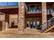 Covered patio with stone columns, staircase access, and views of the landscaped backyard at 4691 Bandera Pl, Parker, CO 80134