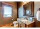 Elegant powder room with granite vanity and decorative mirror at 4691 Bandera Pl, Parker, CO 80134