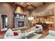 Cozy living room showcasing stone fireplace, exposed beams and a view into the adjacent kitchen at 4691 Bandera Pl, Parker, CO 80134
