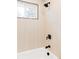 Bright bathroom features a modern tub and shower with sleek, black fixtures at 9380 Raleigh Ct, Westminster, CO 80031