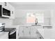 Bright, updated kitchen featuring white cabinets, modern appliances, and quartz countertops at 9380 Raleigh Ct, Westminster, CO 80031