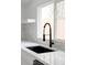 Close up of the kitchen sink and faucet, with white countertops and tile backsplash at 9380 Raleigh Ct, Westminster, CO 80031